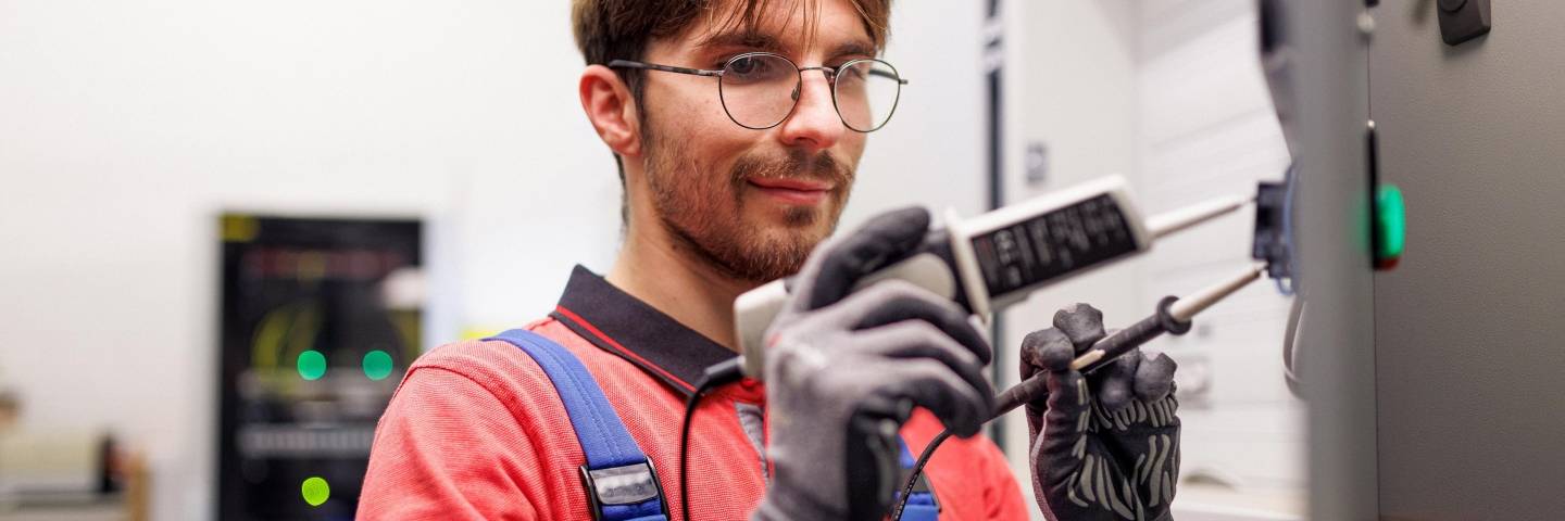Techniker von Kaufland mit einem elektrischen Prüfgerät.