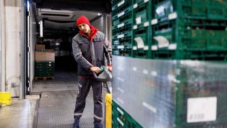 Logistik-Mitarbeiter von Kaufland verlädt eine Warenpalette mit dem Hubwagen.